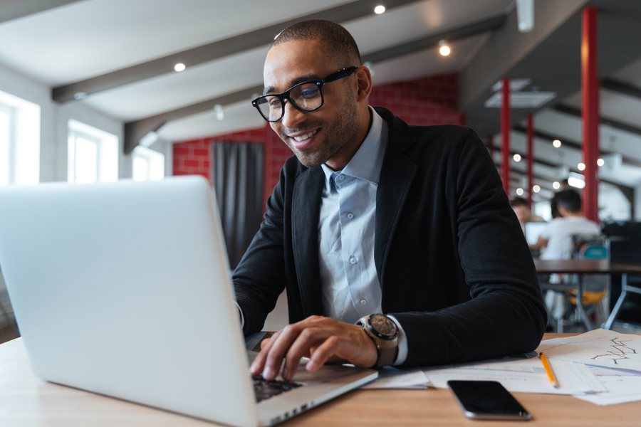 A professional in a blazer working on a laptop